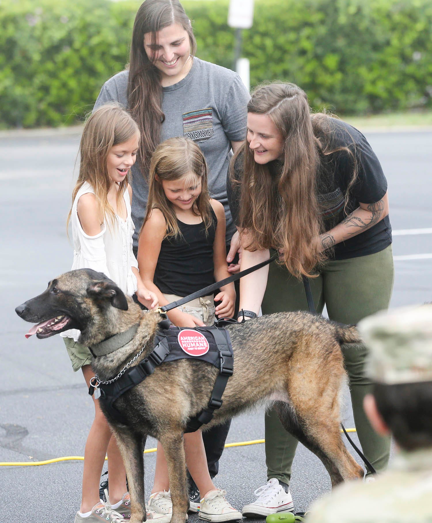 Staff Sgt. Porschia Allio-Easom, a dog handler at Eglin Air Force Base,right, along with daughters Shaylee, Ruby, and  wife Shelby Allio-Easom, stands with retired military dog Luna in a reunion event at the Eglin Federal Credit Union on Eglin Parkway in Fort Walton Beach.