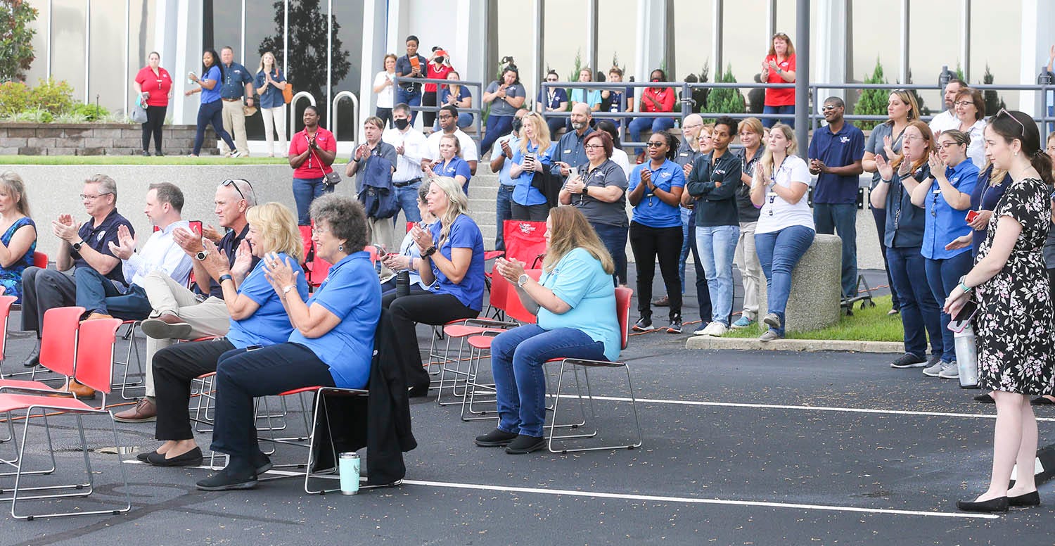 People applaud during the reunion of retired military dog Luna and handler Staff Sgt. Porschia Allio-Easom at the Eglin Federal Credit Union on Eglin Parkway in Fort Walton Beach.