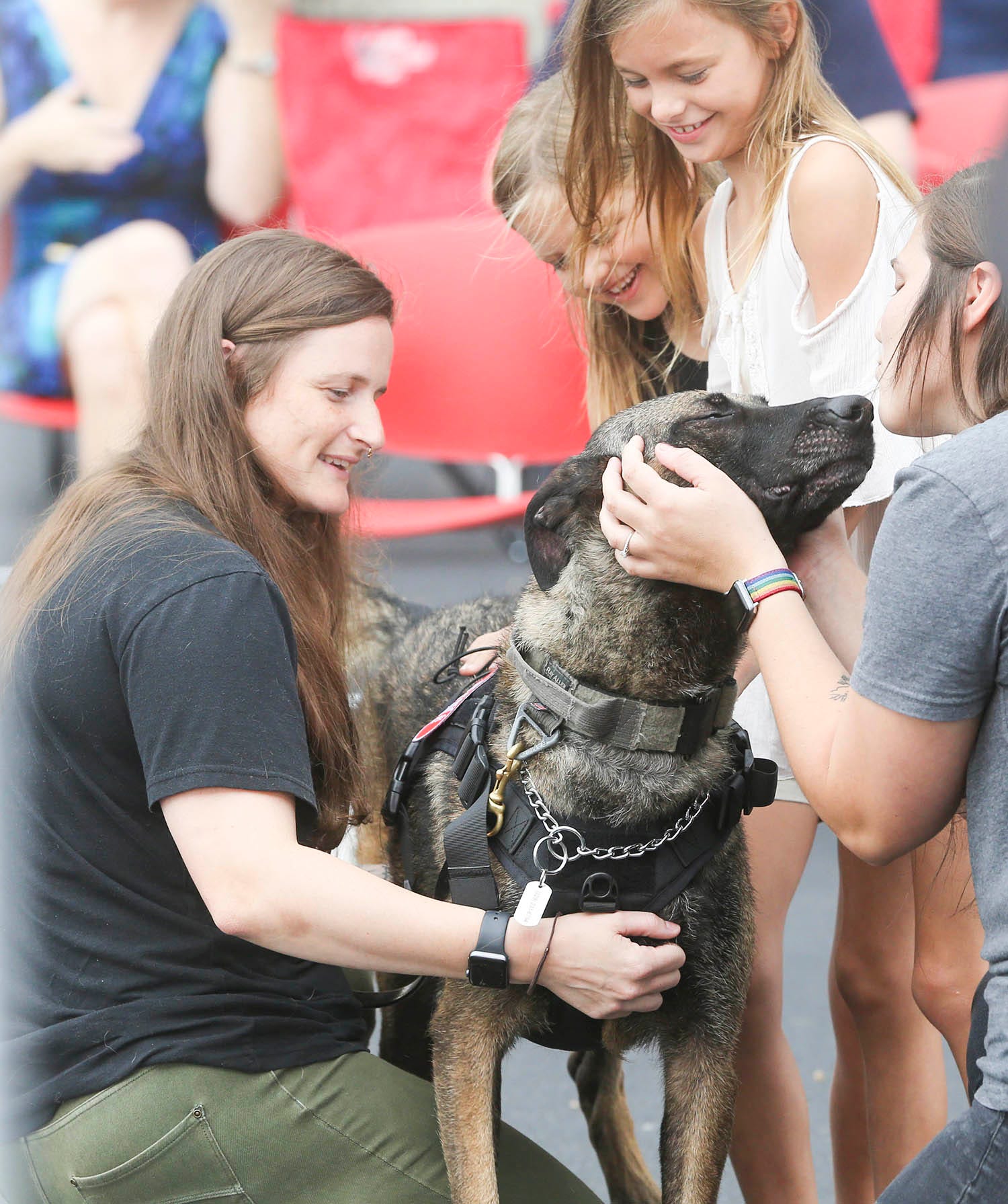 Staff Sgt. Porschia Allio-Easom,left, greets retired military dog Luna in a reunion event at the Eglin Federal Credit Union on Eglin Parkway in Fort Walton Beach along with daughters Ruby Allio, Shaylee Allio and wife Shelby Allio-Easom .